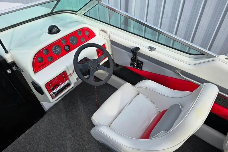 Slide: The Image of 1991 Rinker 236 Captiva Cuddy Cabin boat interior with red and white dashboard. - 3