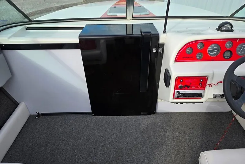 Slide: The Image of 1991 Rinker 236 Captiva Cuddy Cabin dashboard with red instrument panel and black cabinet. - 5