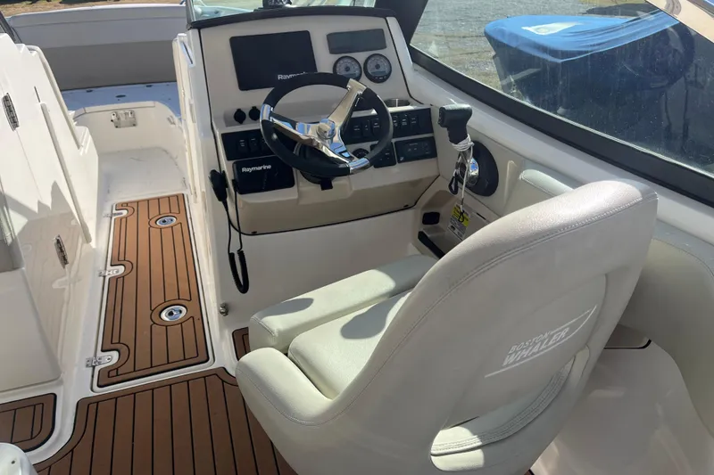 Slide: The Image of 2021 Boston Whaler 240 Vantage boat interior with beige seating and wood flooring. - 12