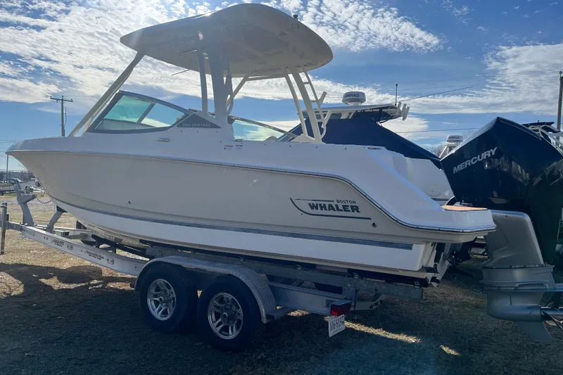 Slide: The Image of 2021 Boston Whaler 240 Vantage boat on trailer under a partly cloudy sky. - 40