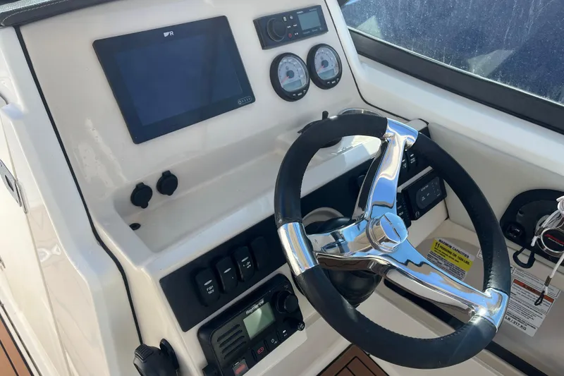 Slide: The Image of Boston Whaler 240 Vantage 2021 with Mercury outboard engine on display outdoors. - 5