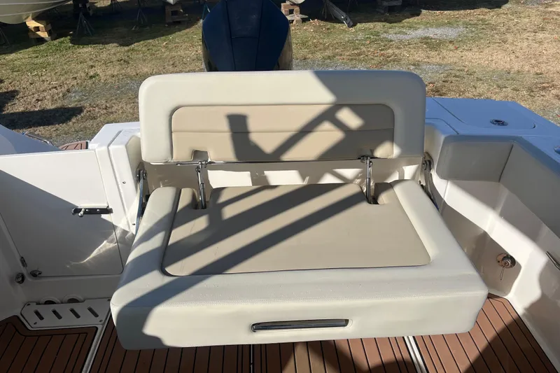 Slide: The Image of 2021 Boston Whaler 240 Vantage interior with cushioned seating and wooden table. - 8