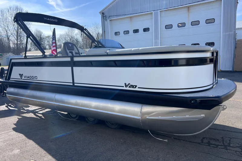 Slide: The Image of 2026 Viaggio V 20U pontoon boat parked outside a garage on a sunny day. - 3