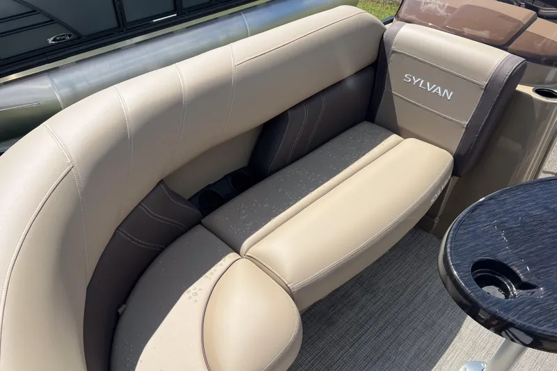 Slide: The Image of 2026 Sylvan Mirage Fish 820 Party Fish boat interior with beige seating and table. - 10
