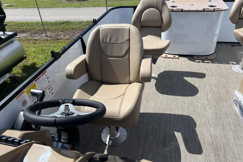 Slide: The Image of 2026 Sylvan Mirage Fish 820 Party Fish boat interior with beige captain's chair and steering wheel. - 14