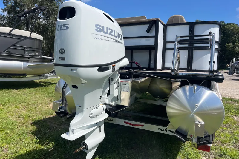Slide: The Image of 2026 Sylvan Mirage Fish 820 Party Fish with Suzuki outboard motor, parked on grass. - 4