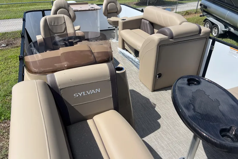 Slide: The Image of 2026 Sylvan Mirage Fish 820 Party Fish boat interior with beige seating and table. - 8