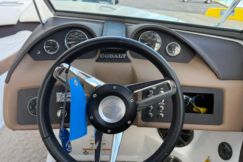 Slide: The Image of Steering wheel and dashboard of a 2015 Cobalt 200 boat, featuring gauges and controls. - 15