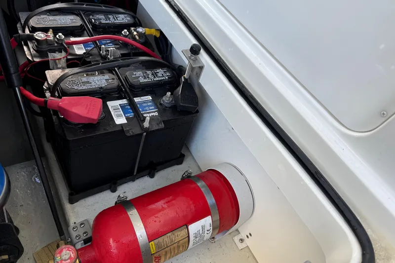 Slide: The Image of 2015 Cobalt 200 boat battery compartment with fire extinguisher and dual batteries. - 17
