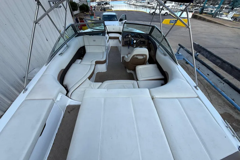 Slide: The Image of 2015 Cobalt 200 boat with canopy, parked outdoors near a marina. - 7