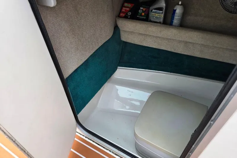 Slide: The Image of Interior of a 1995 Sea Ray 240 Bow Rider boat with storage and supplies. - 11