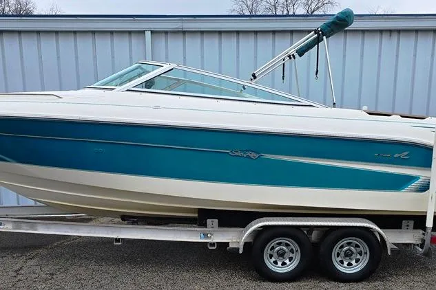Slide: The Image of 1995 Sea Ray 240 Bow Rider boat on trailer, blue and white design. - 25