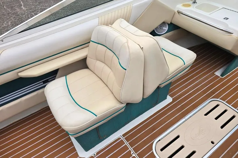 Slide: The Image of 1995 Sea Ray 240 Bow Rider interior with beige seating and wood-patterned flooring. - 5