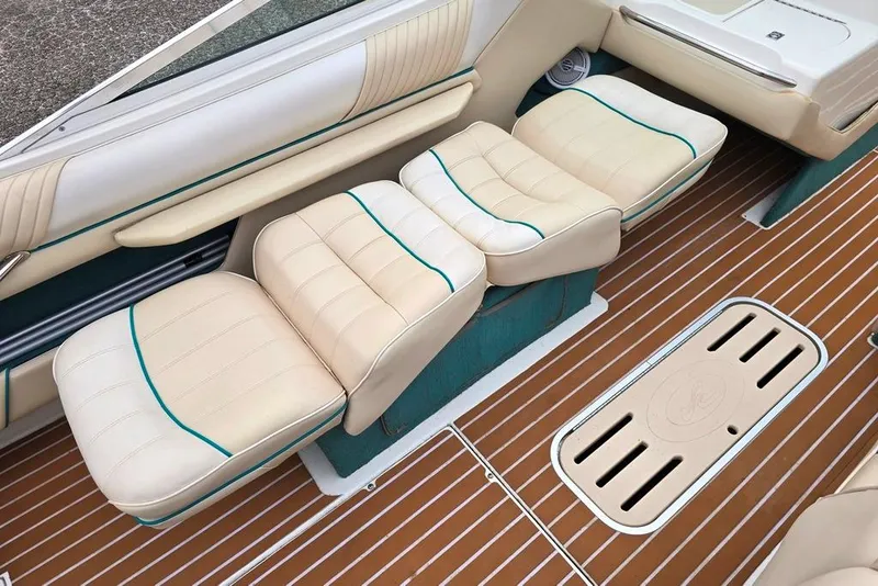 Slide: The Image of 1995 Sea Ray 240 Bow Rider interior with beige seats and teak-style flooring. - 6