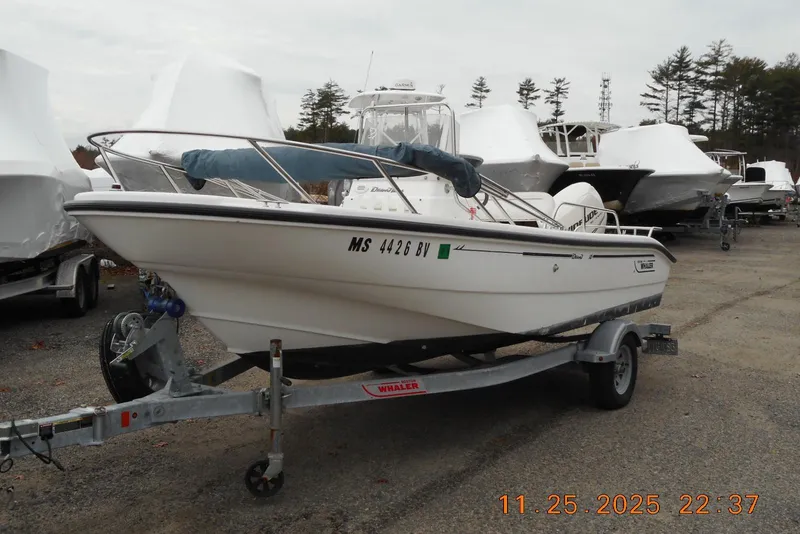 The Image of 2001 Boston Whaler 16 Dauntless boat on trailer in outdoor storage area. - 1