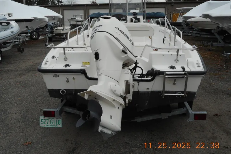 Slide: The Image of 2001 Boston Whaler 16 Dauntless boat with Evinrude motor, parked on a trailer. - 2