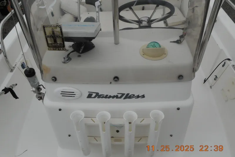 Slide: The Image of 2001 Boston Whaler 16 Dauntless boat console with steering wheel and rod holders. - 5