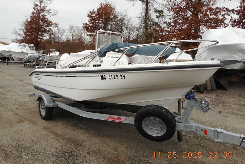 Slide: The Image of 2001 Boston Whaler 16 Dauntless boat on trailer, parked outdoors in autumn setting. - 6
