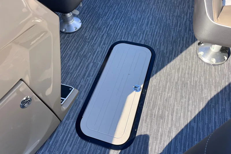 Slide: The Image of Interior view of 2026 Viaggio X 22S Tritoon with carpeted flooring and storage hatch. - 30