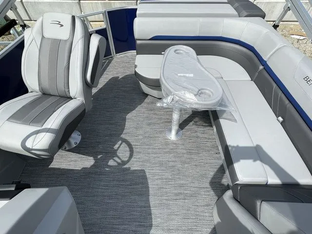 Slide: The Image of 2023 Bennington 20 SXL boat interior with gray seating and a small table. - 9