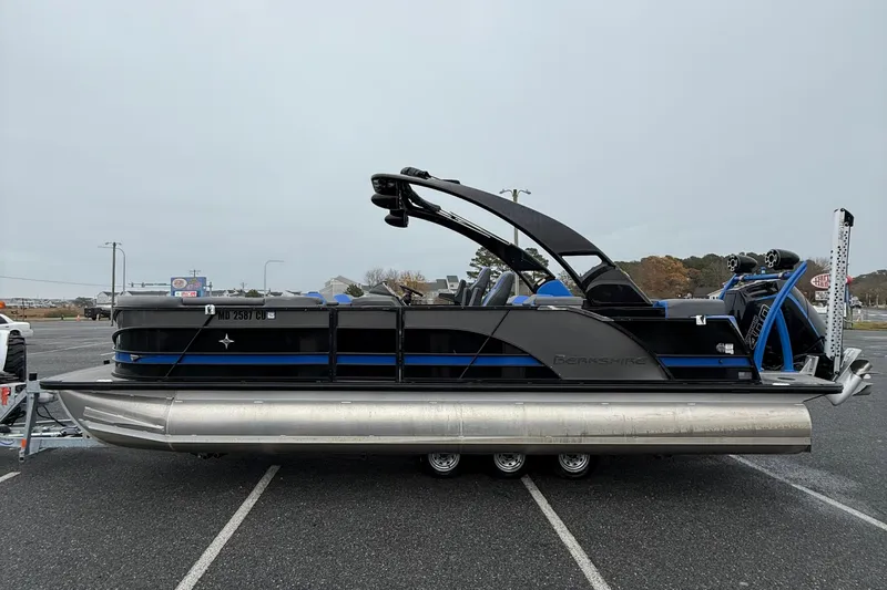 Slide: The Image of 2024 Berkshire 25RFX STS pontoon boat parked in a lot, side view. - 3