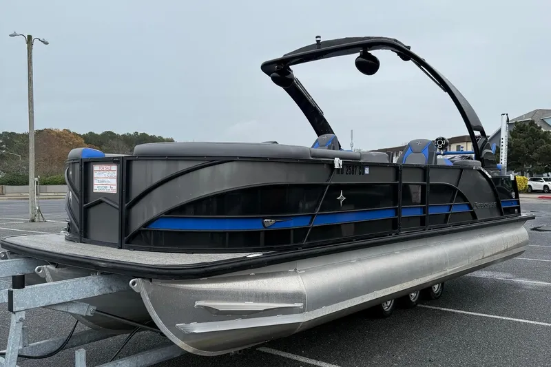 Slide: The Image of 2024 Berkshire 25RFX STS pontoon boat on trailer, black and blue design. - 5