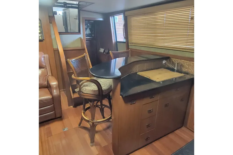 Slide: The Image of Interior of 1988 Chris-Craft 381 Catalina yacht with wooden cabinetry and seating area. - 10