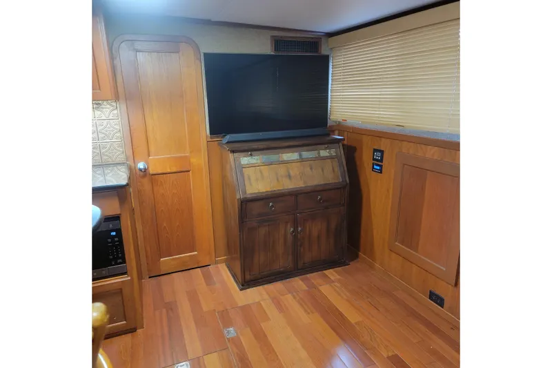 Slide: The Image of Interior of 1988 Chris-Craft 381 Catalina with wood paneling and modern TV setup. - 11