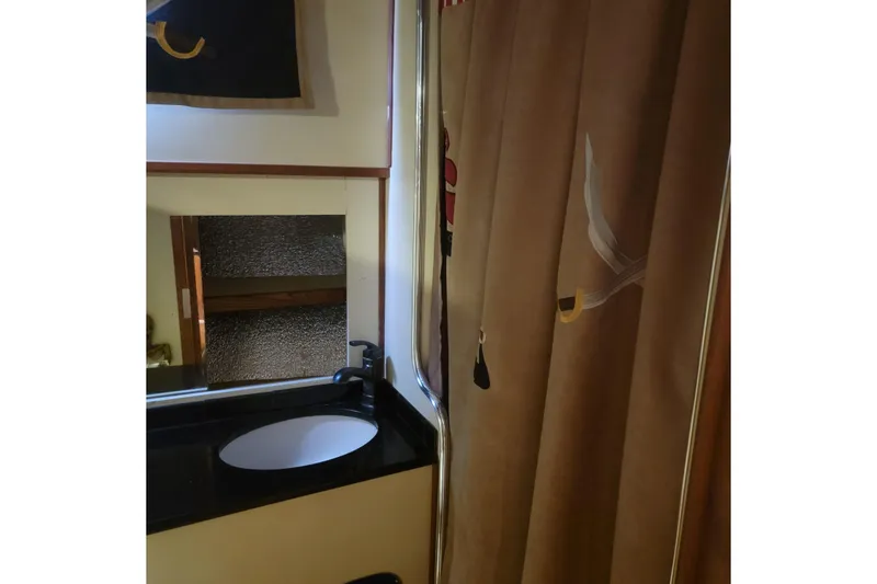 Slide: The Image of 1988 Chris-Craft 381 Catalina bathroom with sink, mirror, and decorative curtain. - 17