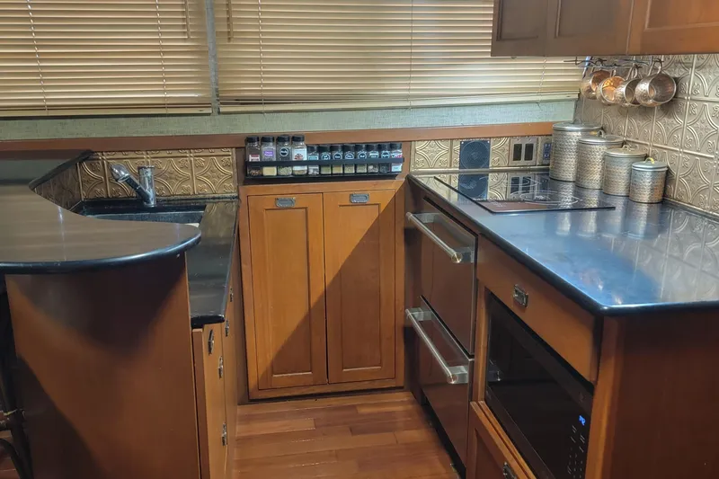 Slide: The Image of 1988 Chris-Craft 381 Catalina kitchen with wooden cabinets, modern appliances, and spice rack. - 9