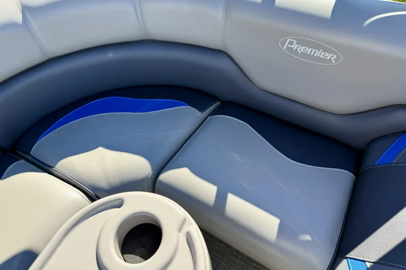 Slide: The Image of 2016 Premier 230 SunSation Echo RF boat seating with cup holder, featuring gray and blue upholstery. - 12