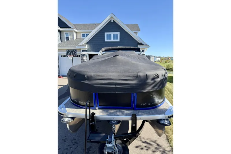 Slide: The Image of 2016 Premier 230 SunSation Echo RF pontoon boat covered, parked in driveway. - 2