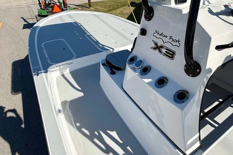Slide: The Image of 2026 Shallow Sport 25 X3 boat with rod holders and canopy, parked outdoors. - 12