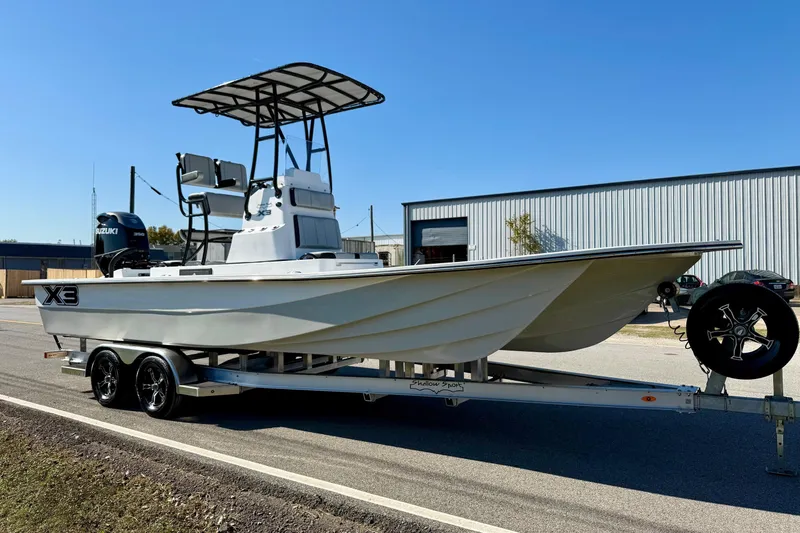 Slide: The Image of 2026 Shallow Sport 25 X3 boat on trailer with Suzuki outboard motor. - 5