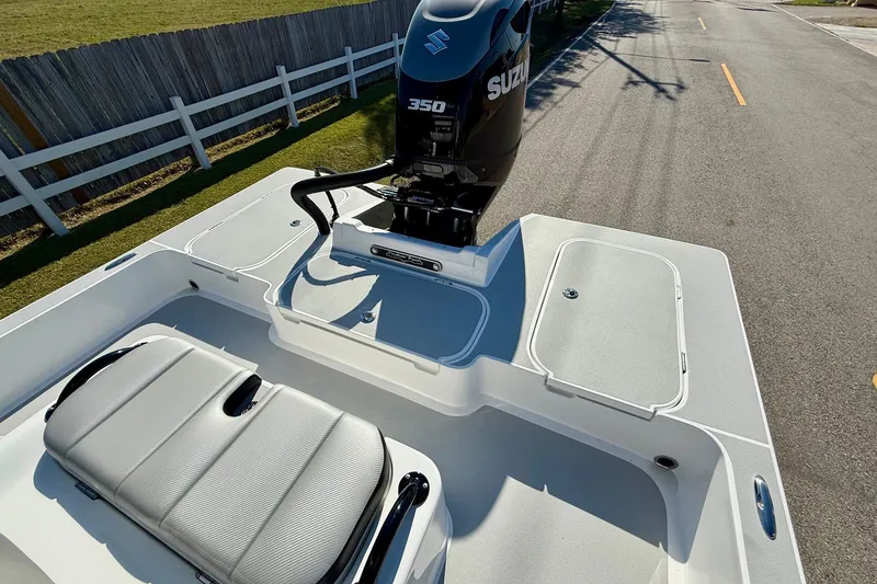 Slide: The Image of 2026 Shallow Sport 25 X3 boat on a road, featuring a sleek design and trolling motor. - 7