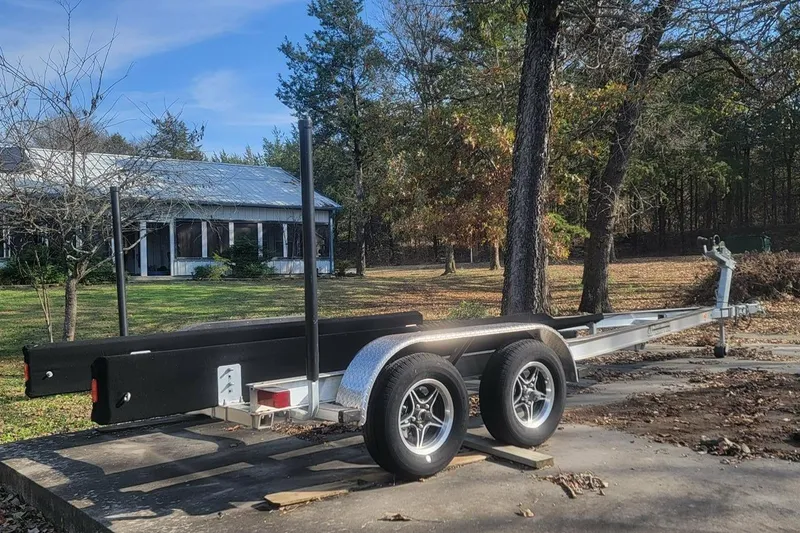 Slide: The Image of Trailer for 2005 Chaparral 256 SSi boat, parked outdoors near trees and a house. - 11
