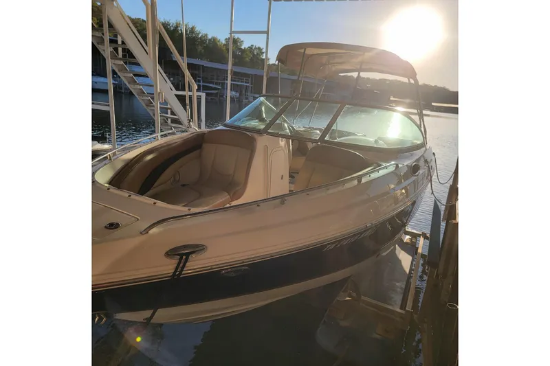 Slide: The Image of 2005 Chaparral 256 SSi boat docked at sunset, featuring sleek design and spacious seating. - 3