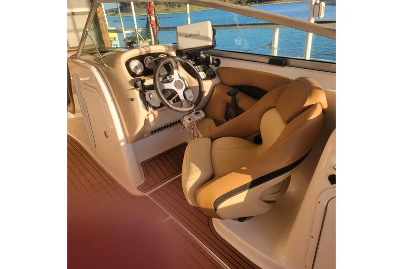 Slide: The Image of 2005 Chaparral 256 SSi boat cockpit with steering wheel and tan seating. - 8
