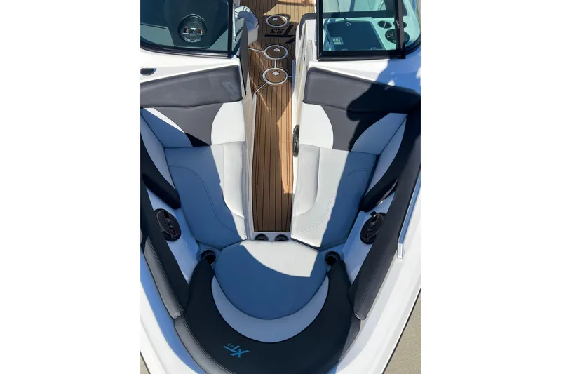 Slide: The Image of 2020 MasterCraft XT23 boat interior with sleek seating and wood accents. - 11