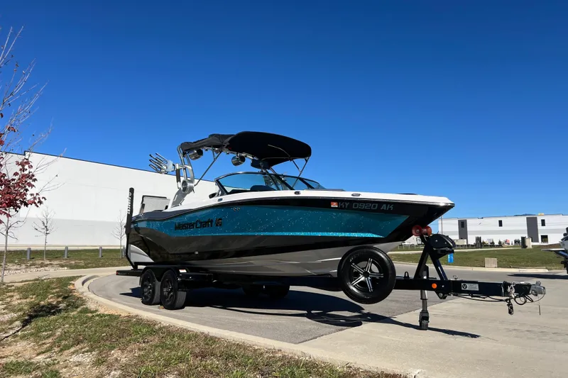 Slide: The Image of 2020 MasterCraft XT23 boat on trailer under clear blue sky. - 5