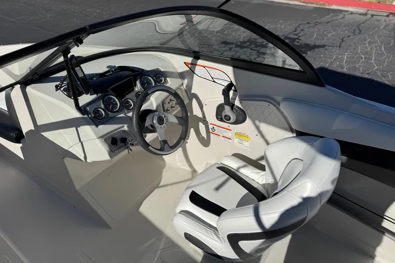 Slide: The Image of 2016 Tahoe 500 TS boat cockpit with steering wheel and white seating. - 23