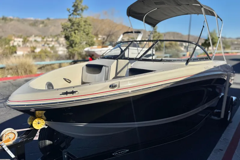 Slide: The Image of 2016 Tahoe 500 TS boat on trailer, parked outdoors with scenic background. - 3