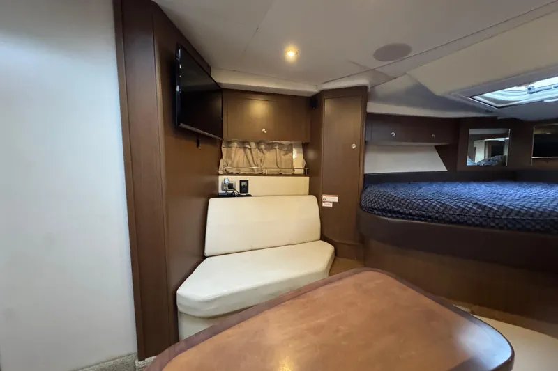 Slide: The Image of 2018 Sea Ray Sundancer 350 Coupe interior with seating, bed, and TV. - 13