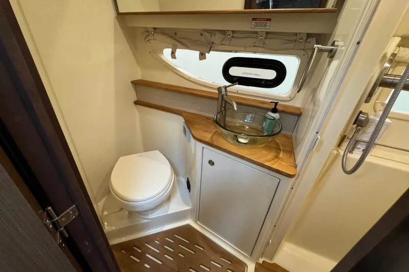 Slide: The Image of 2018 Sea Ray Sundancer 350 Coupe bathroom with modern fixtures and wooden accents. - 16