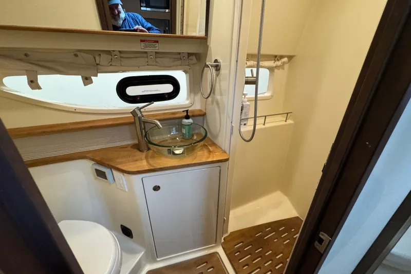 Slide: The Image of 2018 Sea Ray Sundancer 350 Coupe bathroom with modern fixtures and wooden accents. - 17