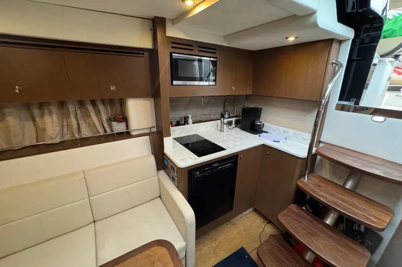 Slide: The Image of 2018 Sea Ray Sundancer 350 Coupe interior with modern kitchen and seating area. - 18