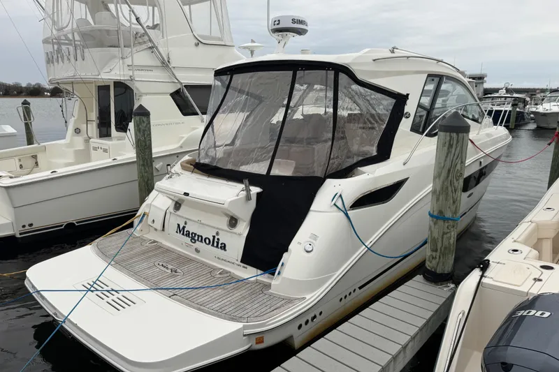 Slide: The Image of 2018 Sea Ray Sundancer 350 Coupe docked at marina, rear view with cover. - 2