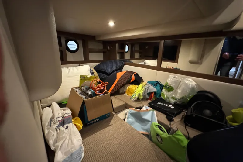 Slide: The Image of Interior of 2018 Sea Ray Sundancer 350 Coupe with various items scattered on seating area. - 21