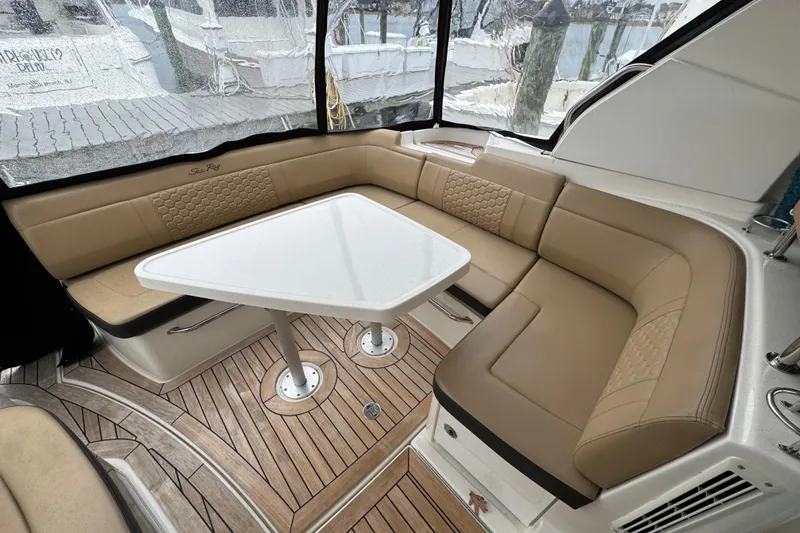 Slide: The Image of 2018 Sea Ray Sundancer 350 Coupe interior with tan seating and white table. - 25