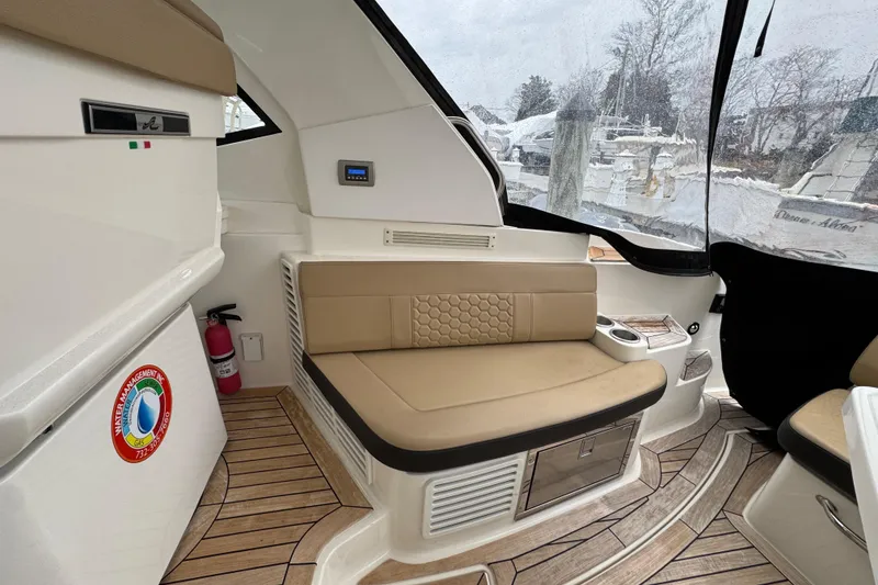Slide: The Image of 2018 Sea Ray Sundancer 350 Coupe interior with beige seating and wood flooring. - 26